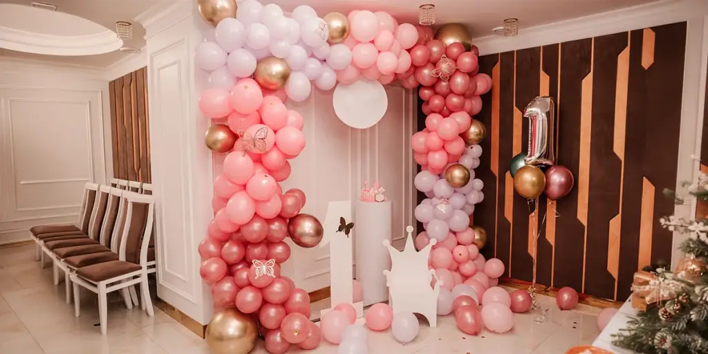 Elegant first birthday balloon arch arranged by reliable event management companies